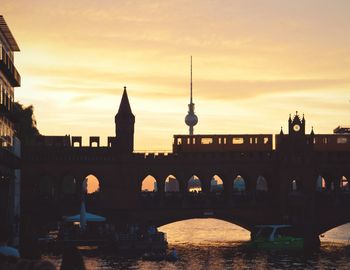 Oberbaum bridge over spree river against fernsehturm during sunset