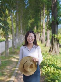 Portrait of young woman standing in park during autumn