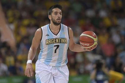 Mid adult man standing against basketball hoop