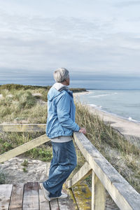 Rear view of man standing on pier