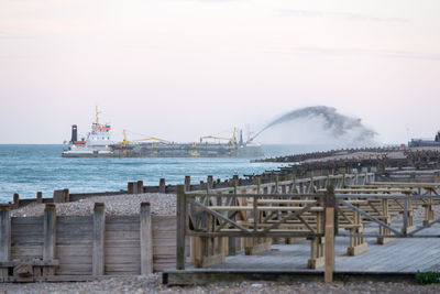 Hopper dredger spraying shingle back onto the beach in eastbourne.
