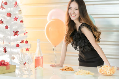 Portrait of a smiling young woman preparing food