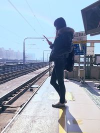 Woman standing on railroad track