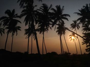 Silhouette palm trees against sky during sunset