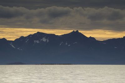 Scenic view of sea and mountains against sky during sunset