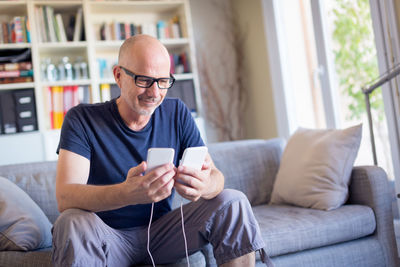 Young man using mobile phone while sitting on sofa