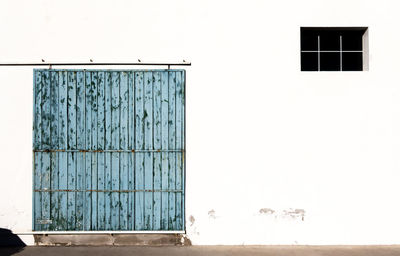 Closed door of building against clear sky