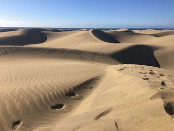 Sand dune in desert against clear sky