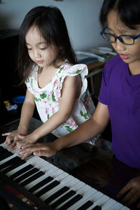 Happy kids playing piano at home