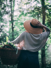 Rear view of man wearing mask against trees in forest