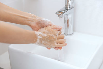 Cropped image of woman washing hands