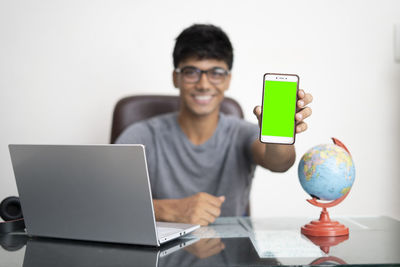 Portrait of young man using laptop on table