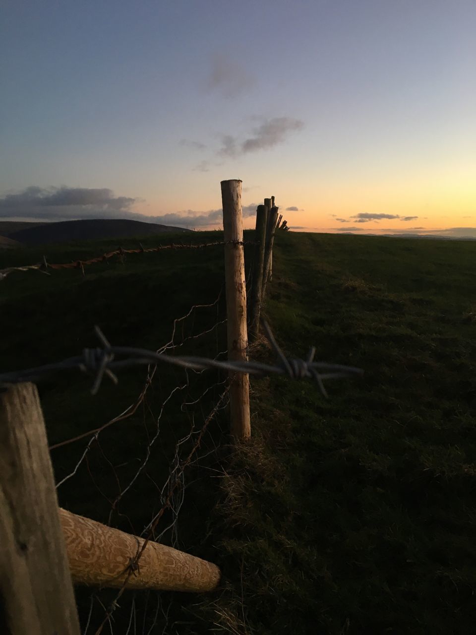 WOODEN FENCE ON FIELD DURING SUNSET