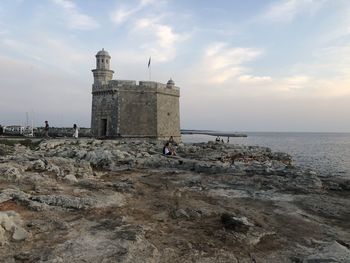 Historic building by sea against sky