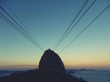 Low angle view of cables against clear sky during sunset