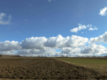 Scenic view of field against cloudy sky