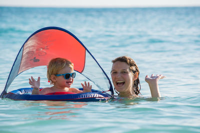 Portrait of siblings in swimming pool at sea