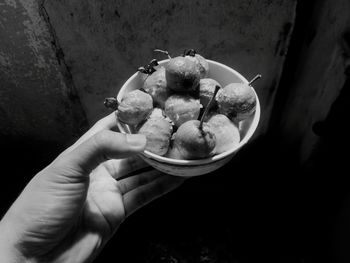 Close-up of person holding guava in bowl