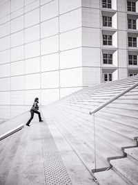 Woman walking on staircase in city