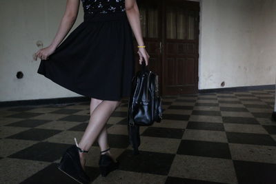 Low section of woman walking on tiled floor