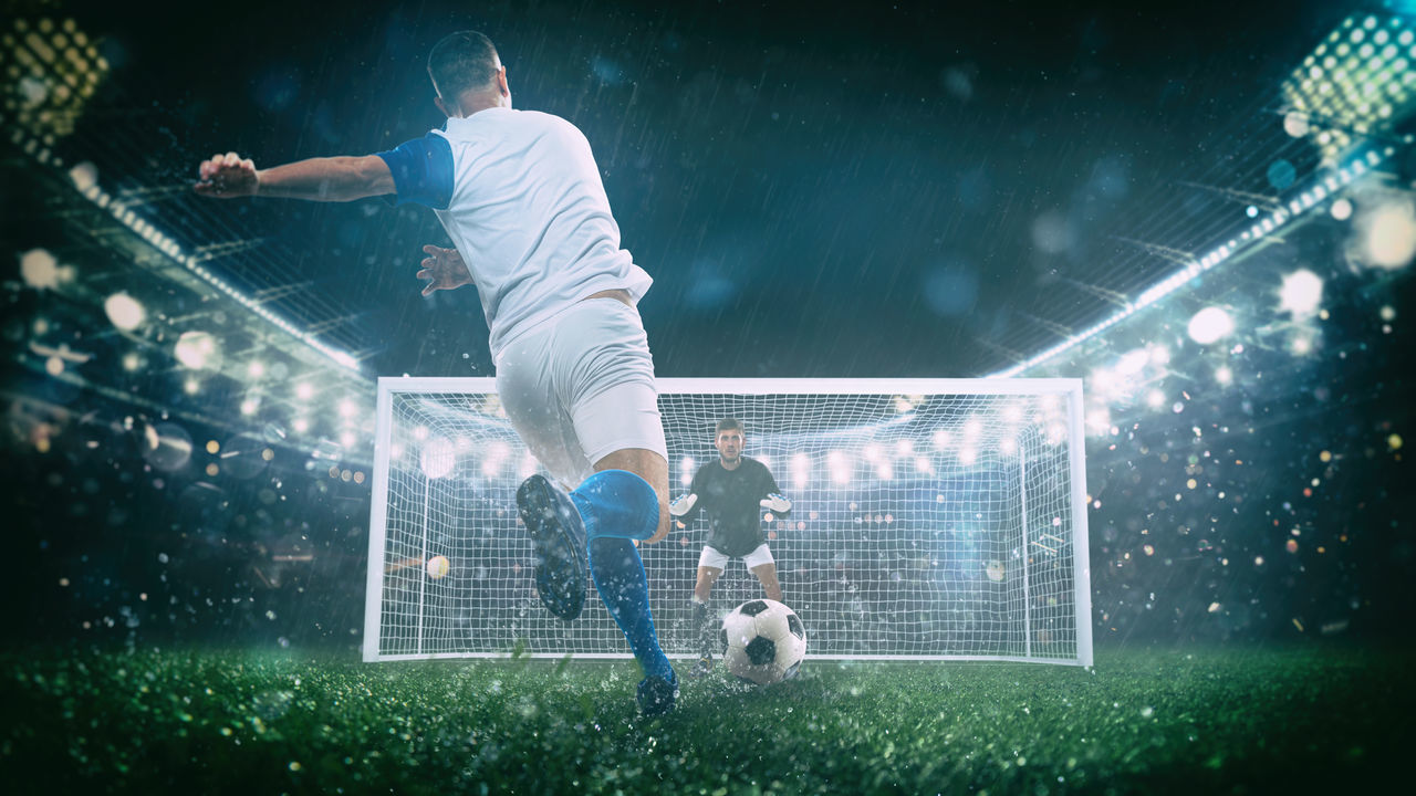 LOW ANGLE VIEW OF MAN PLAYING SOCCER BALL