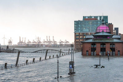 Pier on river against buildings in city