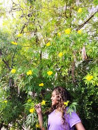 Woman standing by flowering tree