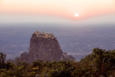 Temple on mountain against sky during sunset