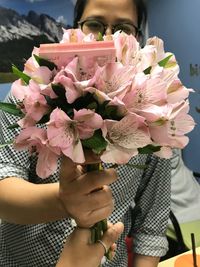 Midsection of woman holding flowers