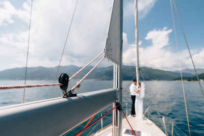 People sailing on sea against sky