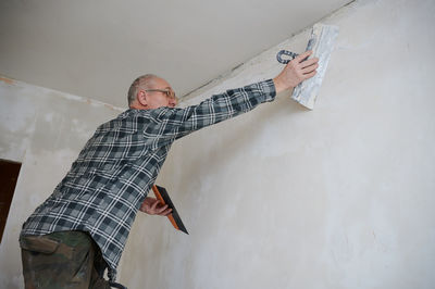 Low section of man standing against wall