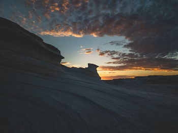 Low angle view of silhouette rock formations against sky during sunset