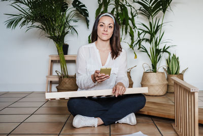 Young woman sitting on chair at home