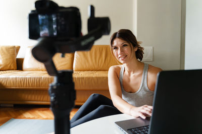 Portrait of young woman using mobile phone at home