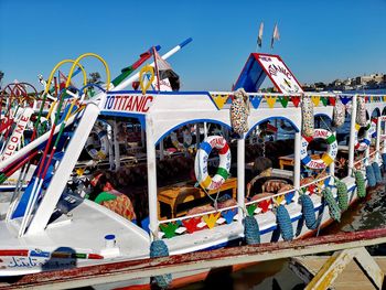 Illuminated ferris wheel at amusement park against sky