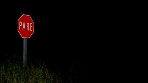 Close-up of road sign against black background