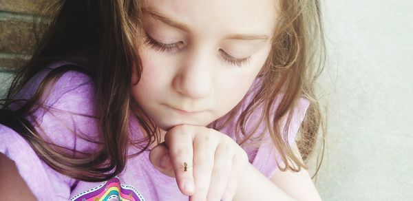 Close-up of cute girl looking at insect