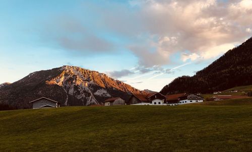 Built structure on field by mountains against sky