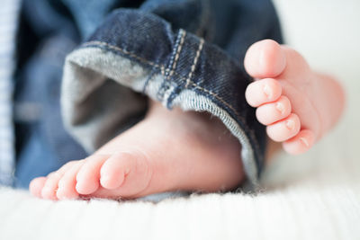 Low section of baby on bed