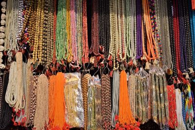 Multi colored decorations hanging in store for sale at market stall