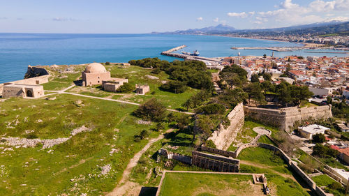 High angle view of buildings and sea against sky