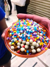 High angle view of hand holding multi colored candies