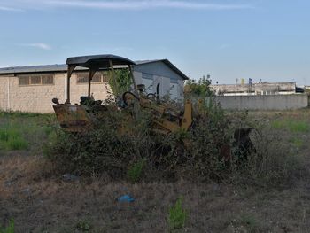 Abandoned built structure on field against sky