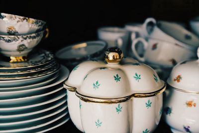 Close up of tea cups and saucers against black background