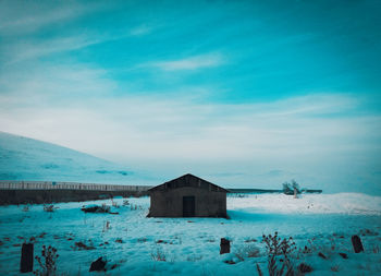 Built structure by sea against sky during winter