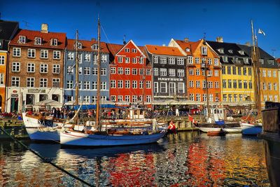 Boats moored by multi colored houses