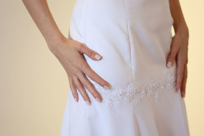 Midsection of bridge standing against beige background