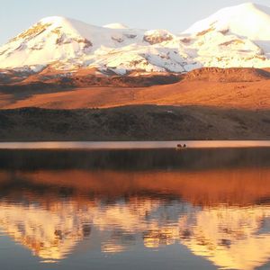 Scenic view of lake by snowcapped mountains against sky