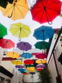 Low angle view of umbrellas hanging against sky