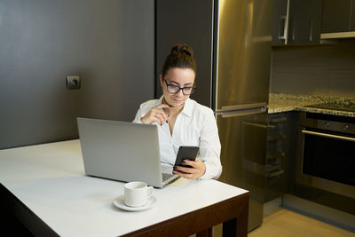 Young woman working with laptop in evening